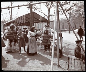 View of a woman pushing children on the swings at Tompkins Square Park, on Arbor Day, New York